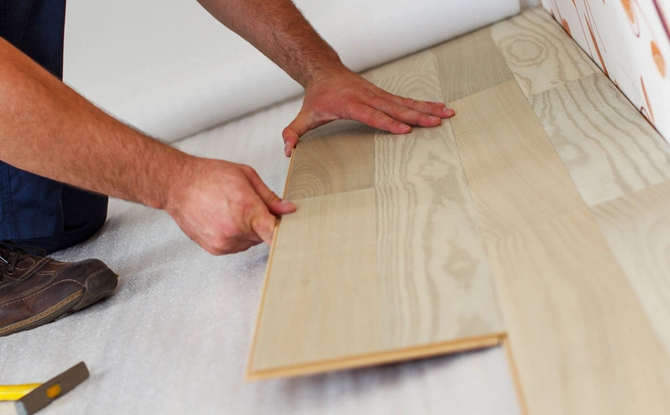 A person is holding the floor board of a bed.